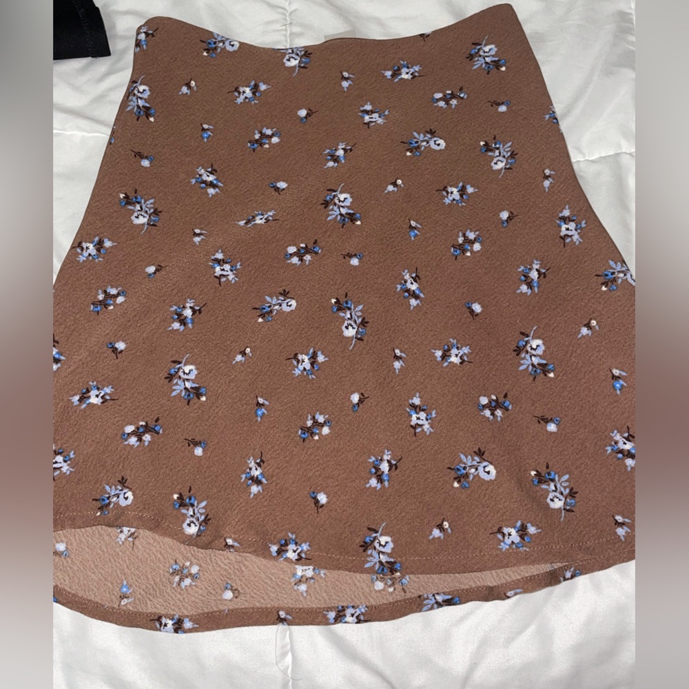 Brown skirt, blue floral pattern, and slightly ruffled at bottom.